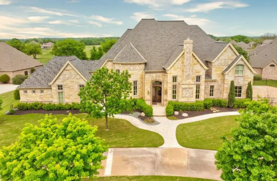Elevated view of a limestone home with a branching front walk and landscaped lawn