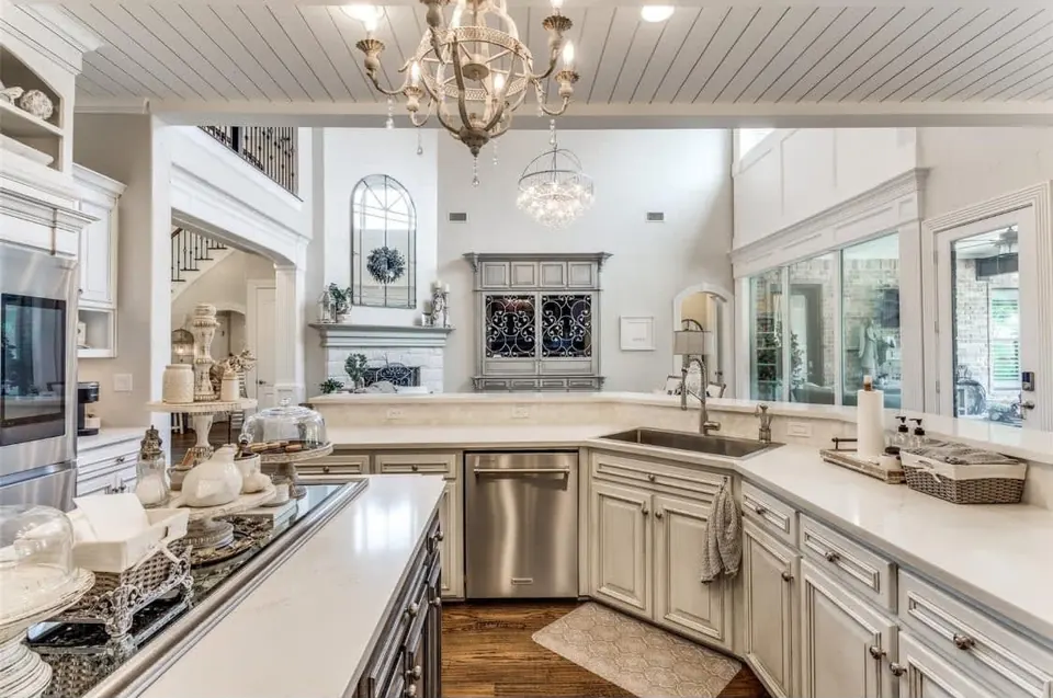 Kitchen sink run with painted cabinets, quartz counters and a planked ceiling