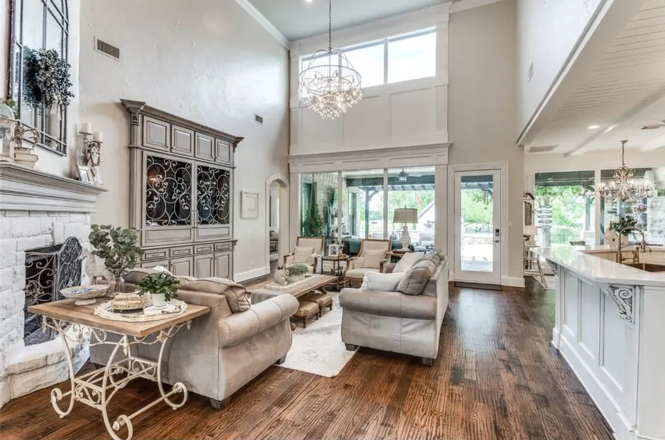 Living room with a tall fireplace wall, clerestory windows and a chandelier