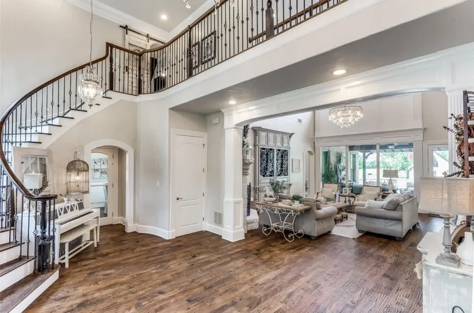 Curved staircase with an iron balustrade overlooking the living room