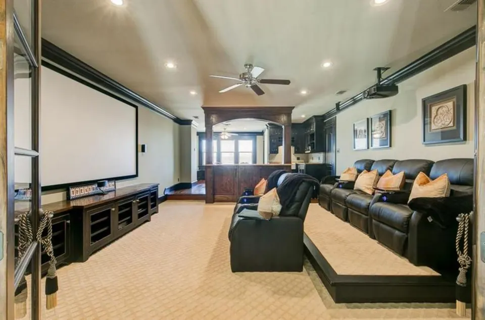 Media room with tiered leather seating and a projection screen