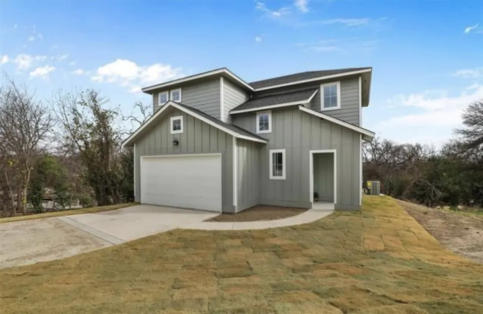 Gray two-story home with a front-gabled garage on a newly graded lot